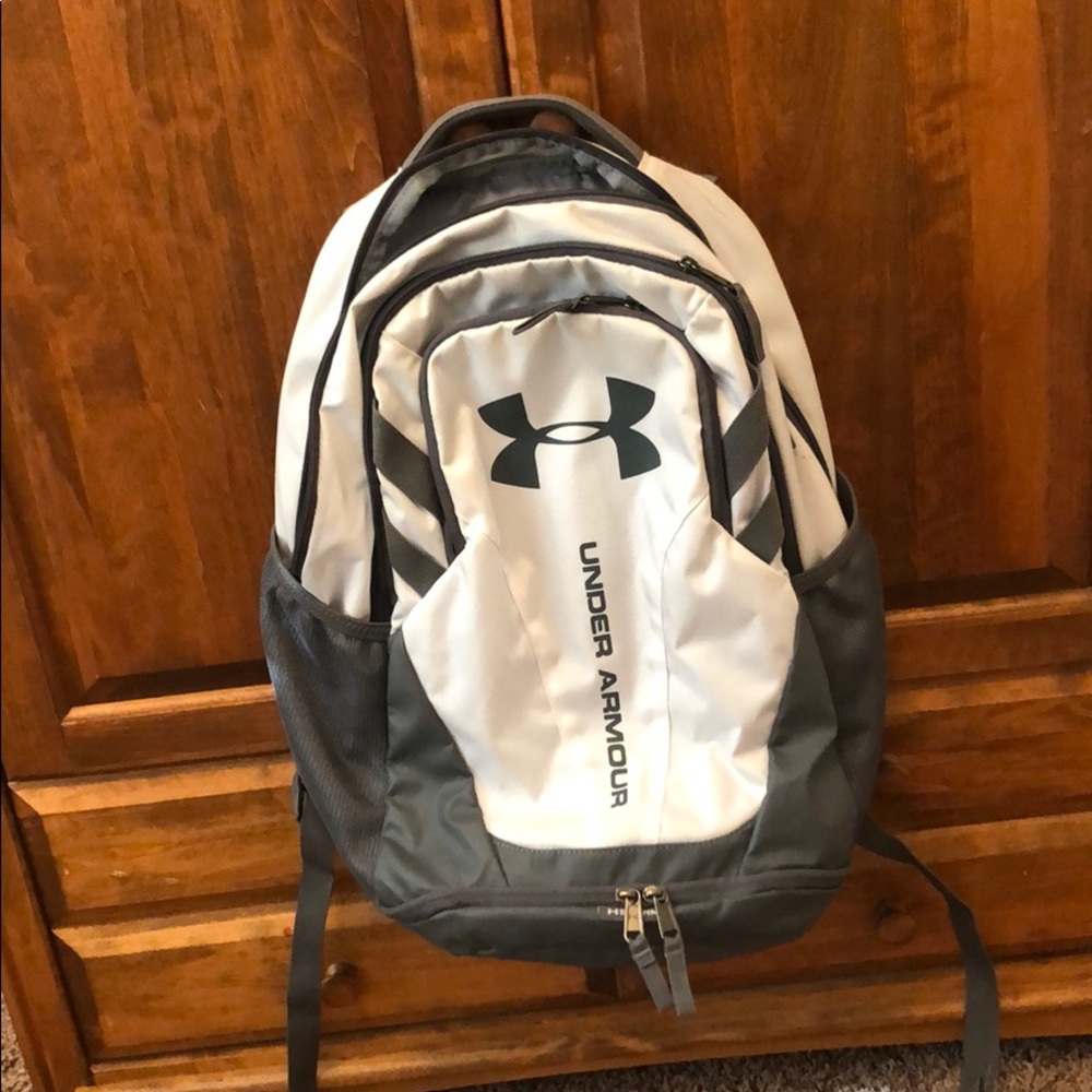 Grey and white under armour back pack.